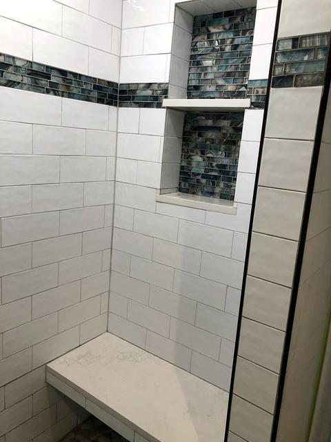 Subway tile shower with glass mosaic niche and bench in Burleson