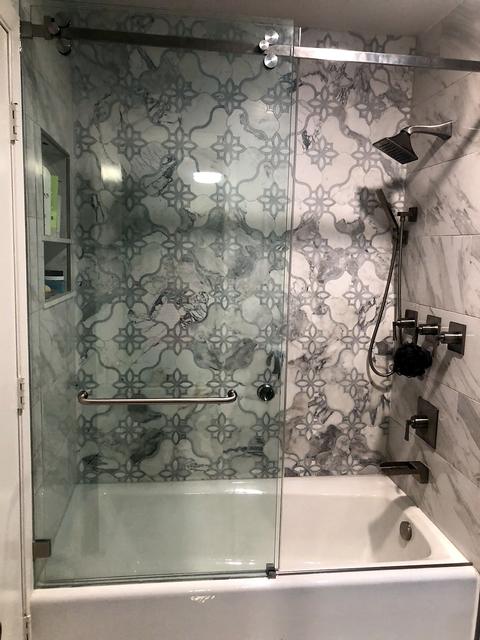 Mosaic tile tub surround with glass door in Arlington