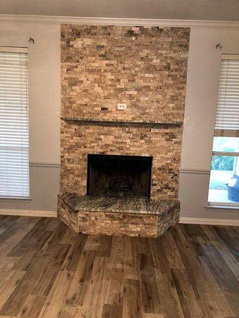 Travertine fireplace with wood-look floor